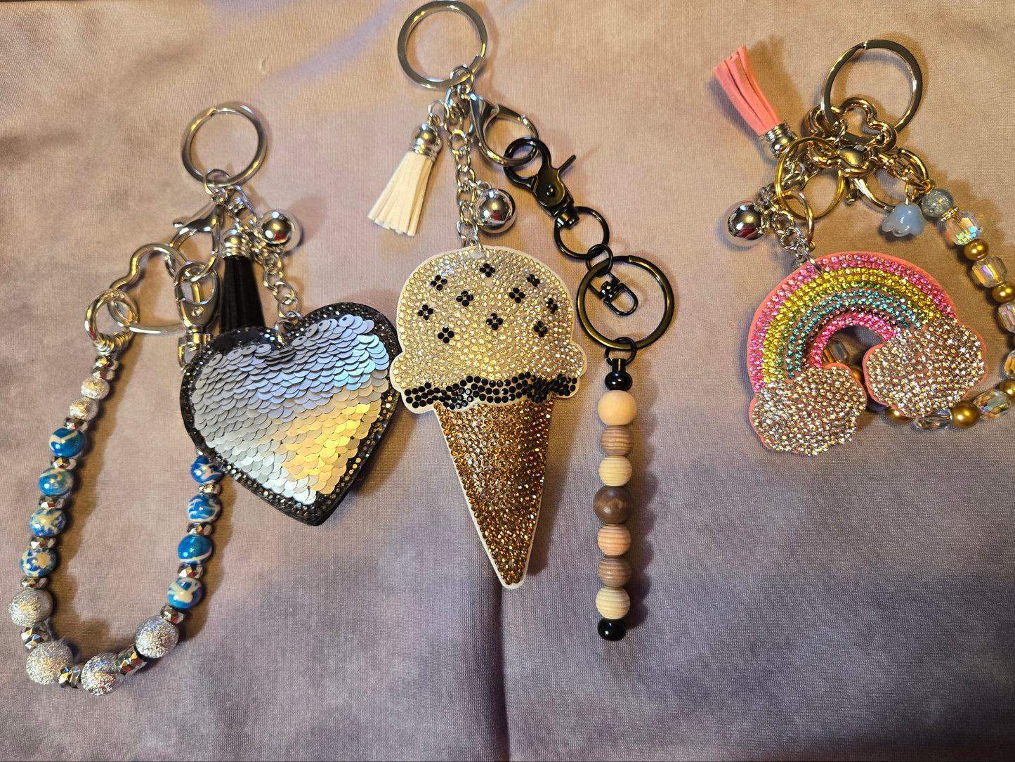 Four decorative keychains with heart, ice cream, and rainbow designs 