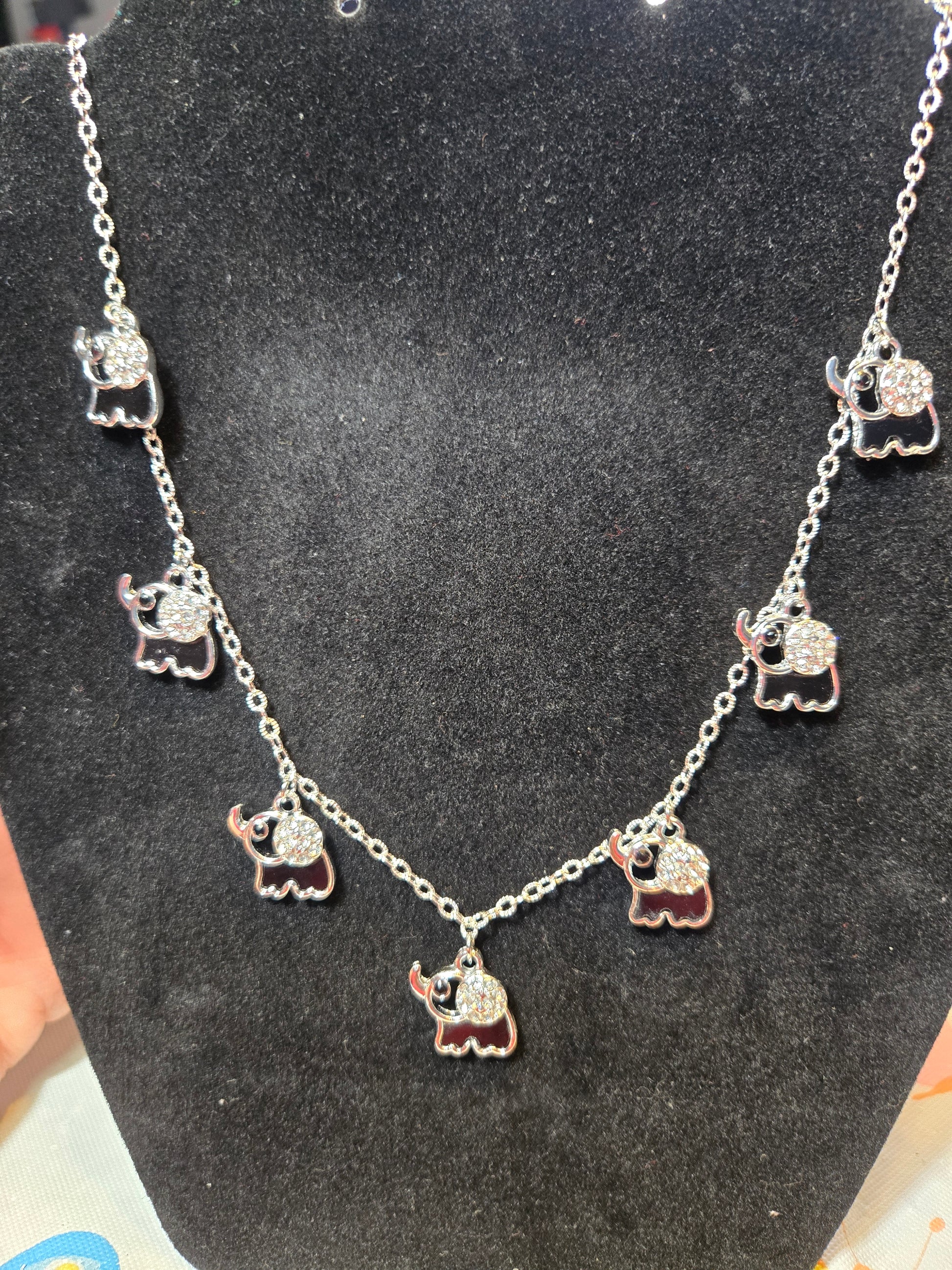 Silver necklace with elephant charms.  Bling on the ears and Elephant is an open design.